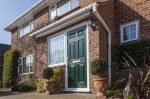 Green composite doors Stourbridge with window next to it in modern home