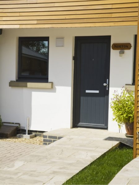 black composite doors Worcester with paved path to door and tree outside
